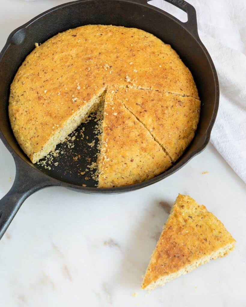 completed cornbread in a skillet with a piece missing