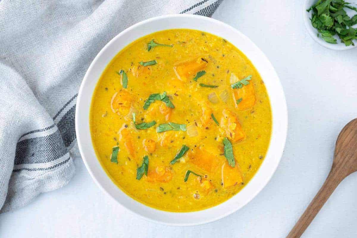 Top view of a bowl of curried butternut squash lentil soup.