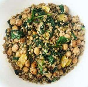 Top view of lentil chickpea salad with greens in a bowl.