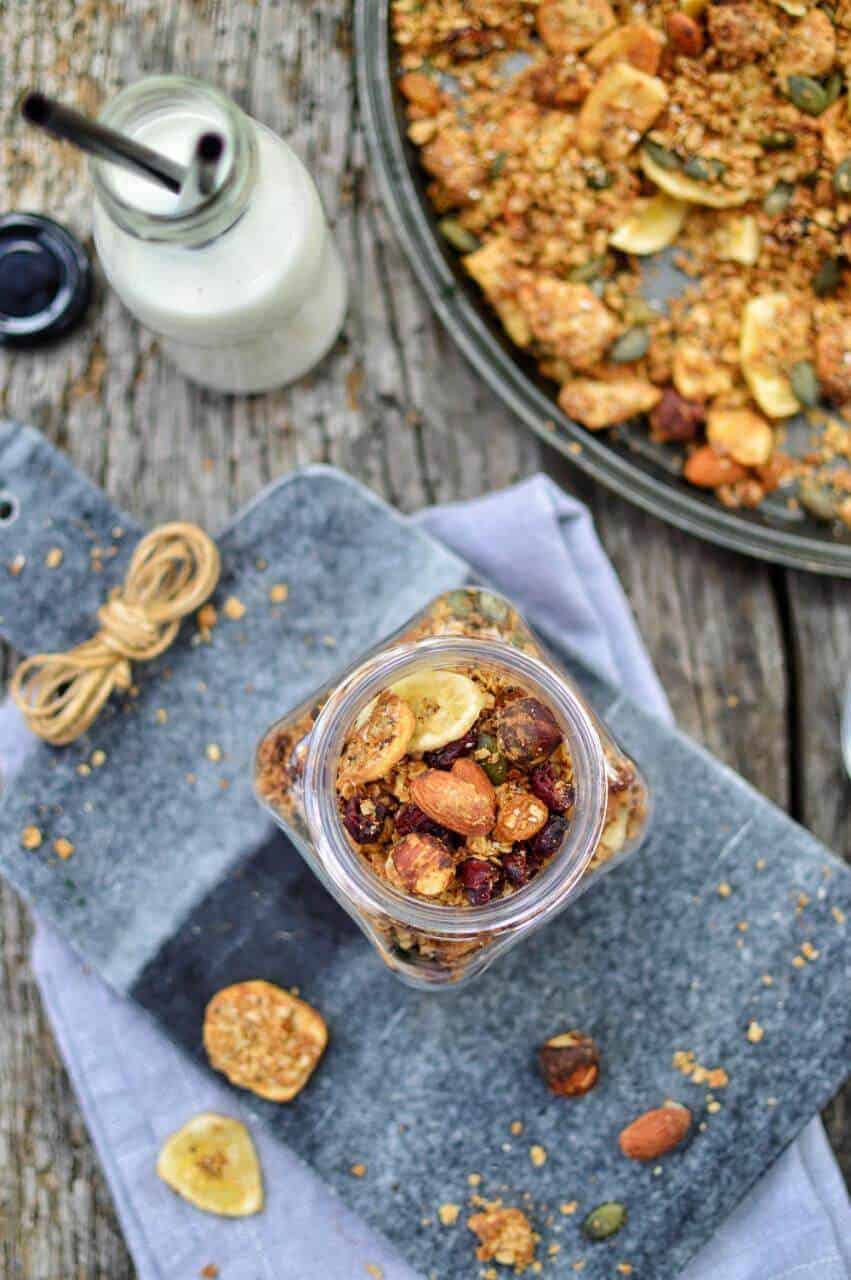 A baking sheet and a jar filled with homemade vegan granola.