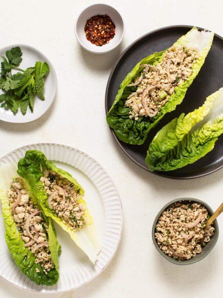 completed Larb Salad Recipe with two plates plated with larb salad against. a white background