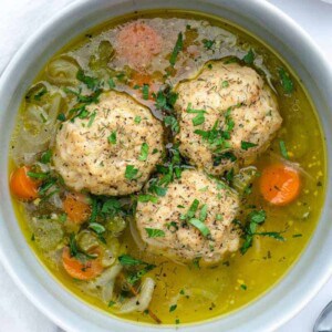 finished matzo ball soup with carrots in a white bowl