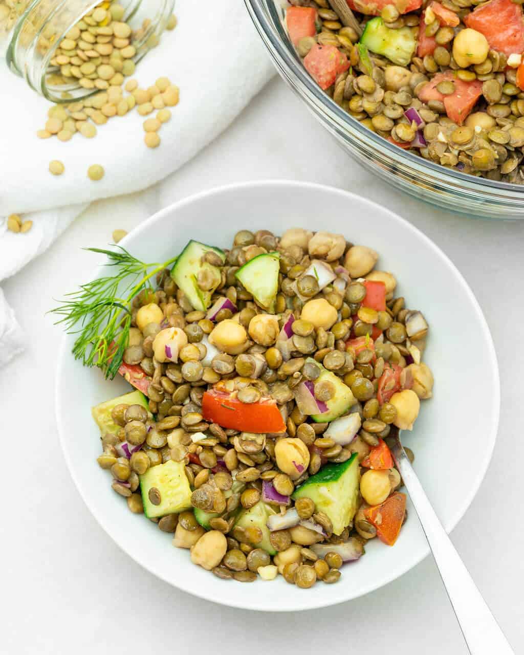 Top view of Mediterranean lentil salad in a white bowl.