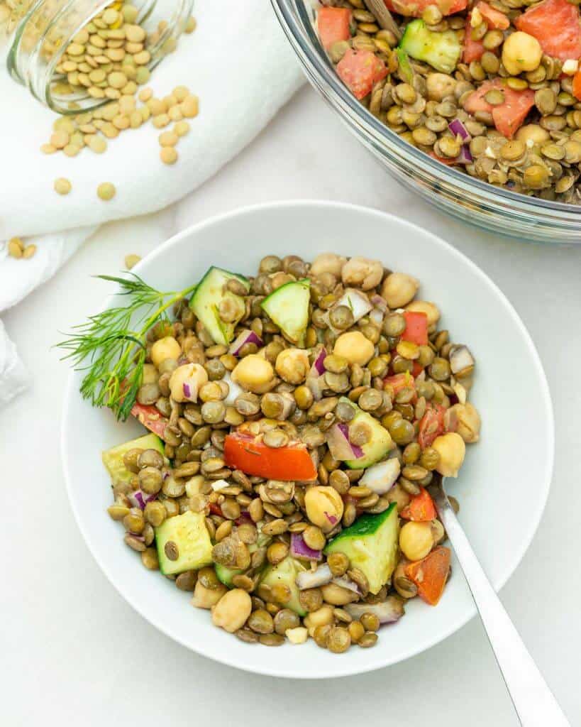 completed Mediterranean Lentil Salad plated on a white plate against a white background