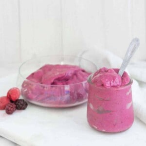 Mixed berry ice cream in a small jar with a spoon.