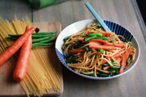 Bowl and fork with savory noodles and veggies.