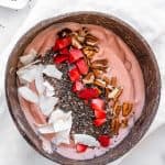 pb&j smoothie bowl in a brown coconut bowl against a white background