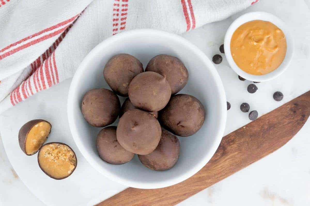Chocolate covered cookie dough bon bons in a small white bowl.