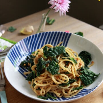 Peanut spaghetti with kale in a patterned bowl.
