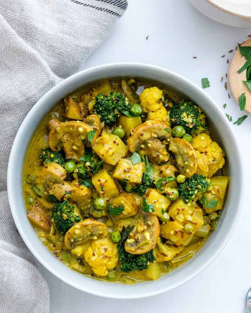 Perfect Potato and Pea Coconut Curry in a white bowl against a white background