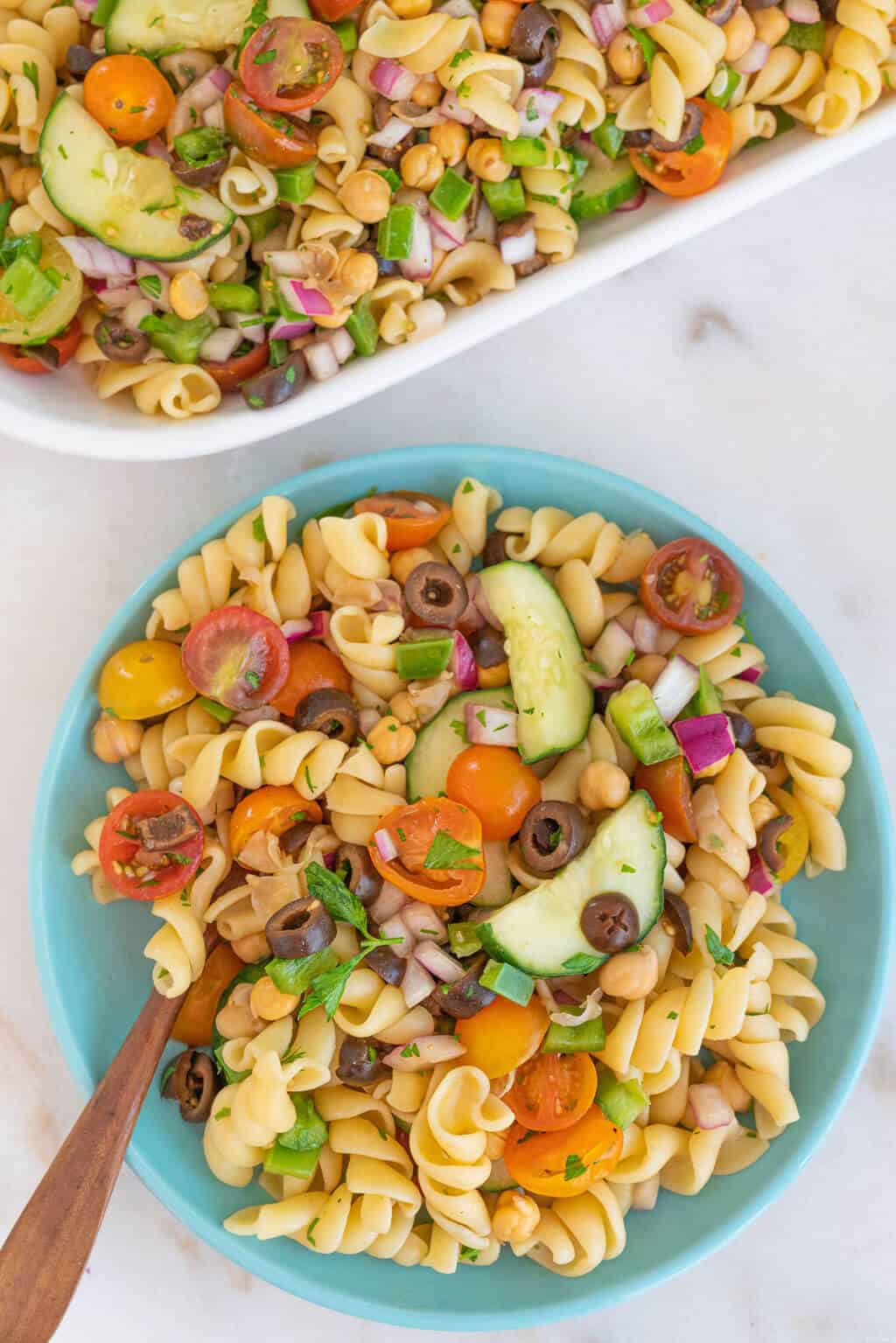 A blue bowl with a large helping of perfect veggie pasta salad.