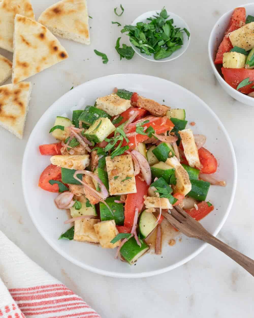 Pita Panzanella salad in a white bowl with a fork.