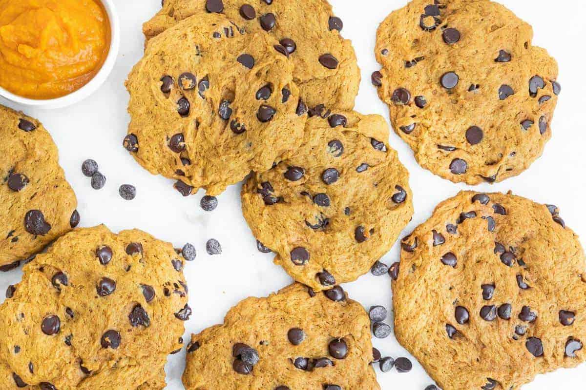several finished pumpkin chocolate chip cookies on a white background