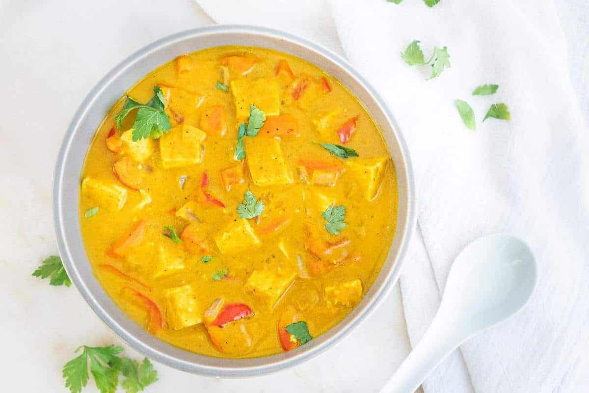 finished bowl of pumpkin curry against a white marble background