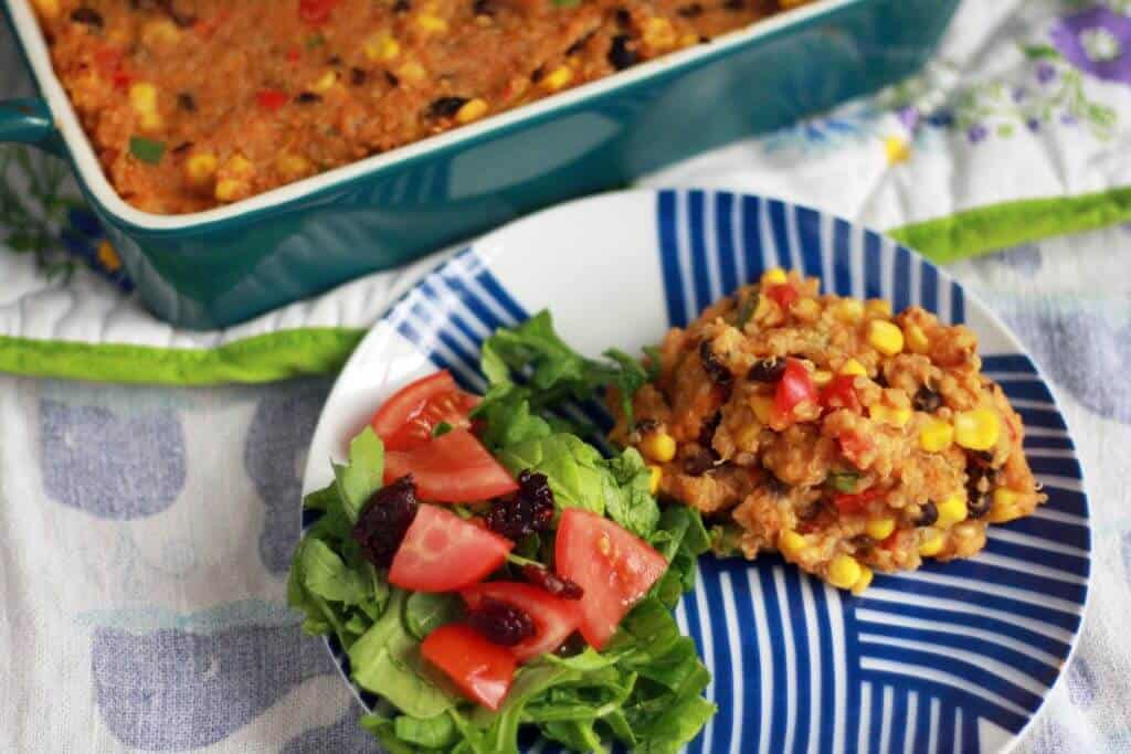 Quinoa casserole and green salad on a plate.