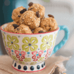 Oatmeal raisin protein balls stacked in a tea cup.