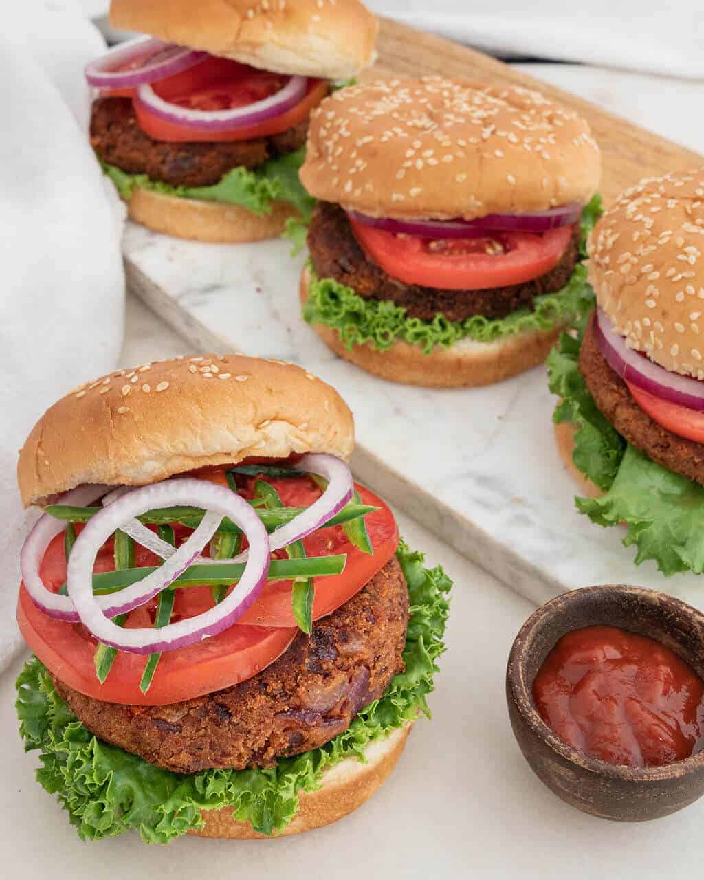 Spicy Red Bean Burgers on buns loaded with all the fresh toppings.