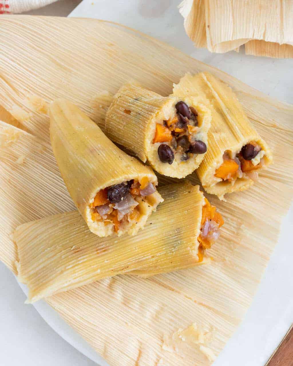 four completed tamales on a light surface