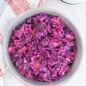 Large white serving bowl filled with sweet and sour red cabbage.
