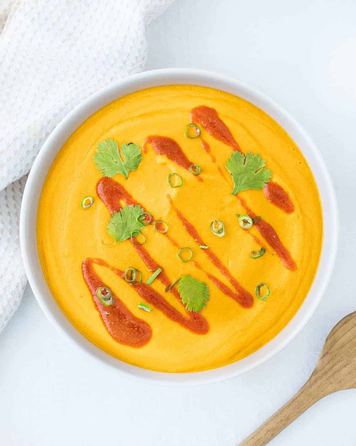 Top view of a white bowl filled with Thai Style Butternut Squash Style Soup.