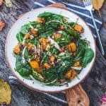 Perfect fall spinach salad in a large white serving bowl.
