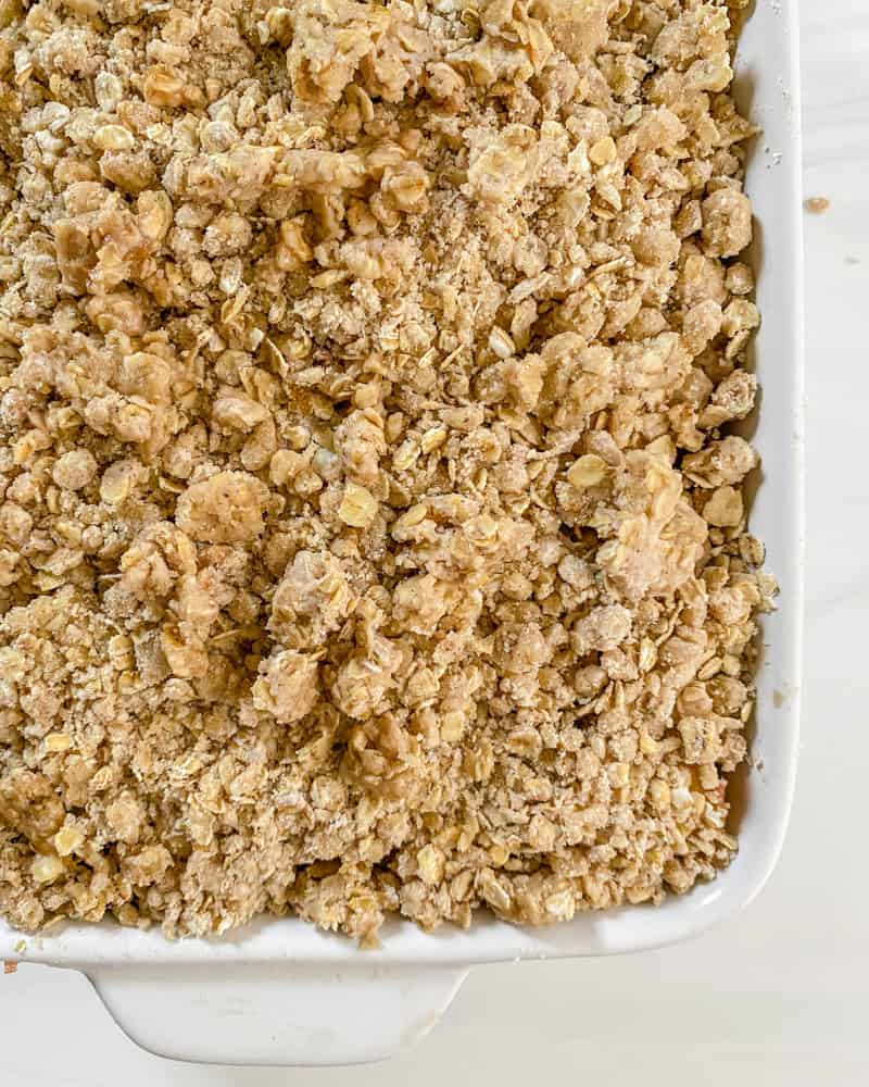 Process shot showing pre-baked plum crisp in baking pan.