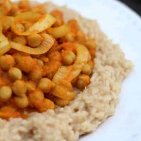 Chickpea tandoori over brown rice on a white plate.