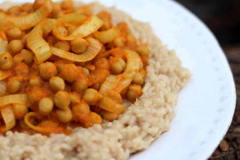 Chickpea tandoori over brown rice on a white plate.