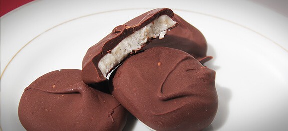Peppermint patties stacked on a white plate.