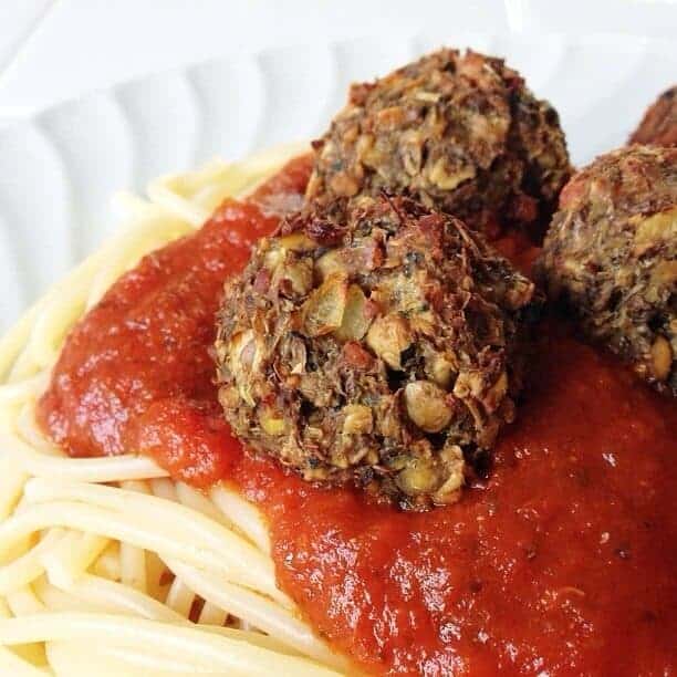 Meatless meatballs with red sauce on top of spaghetti.