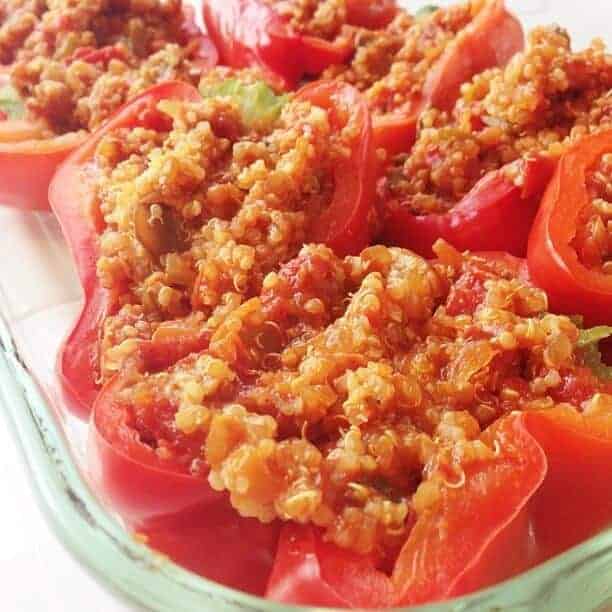 Closeup of quinoa stuffed peppers in a baking dish.