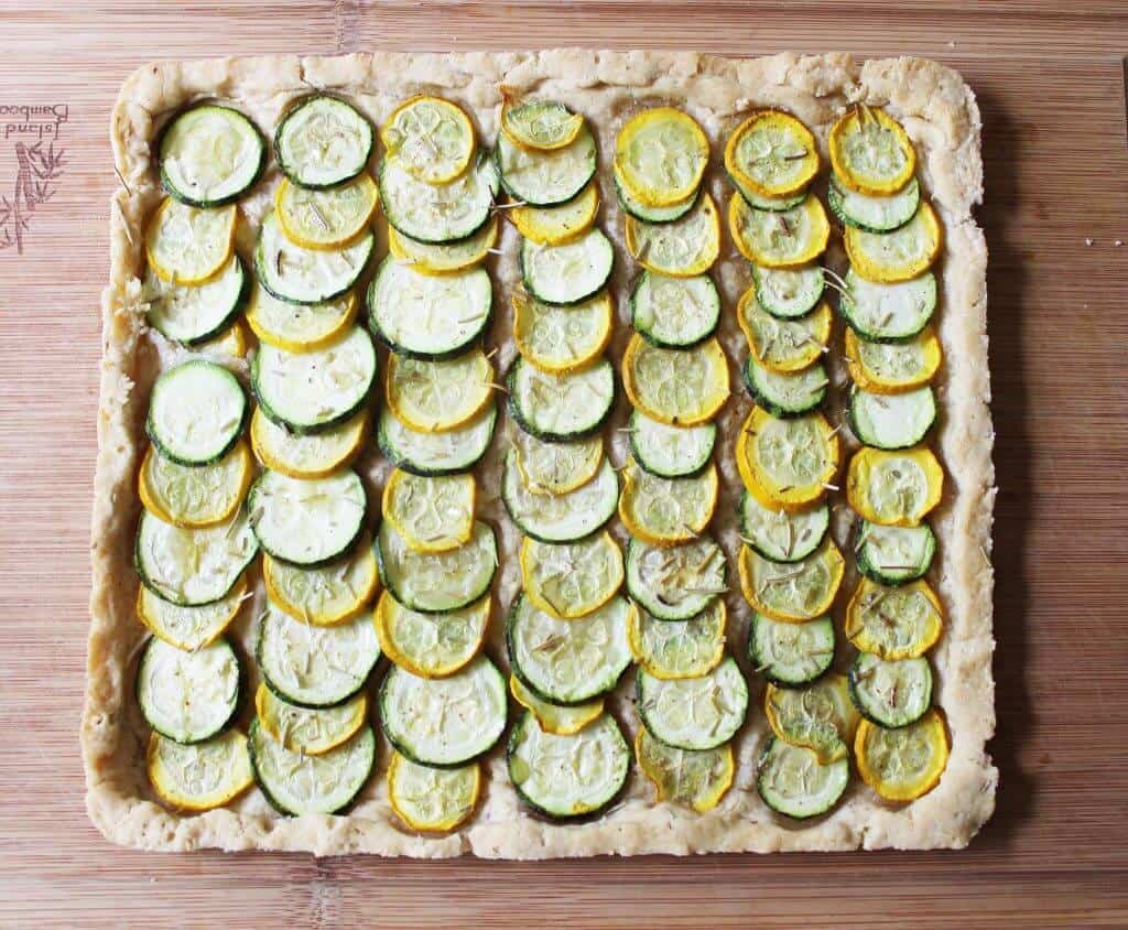 Top view of rows of sliced zucchini in a tart crust.