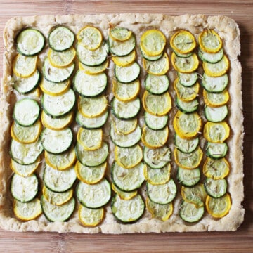 Top view of rows of sliced zucchini in a tart crust.