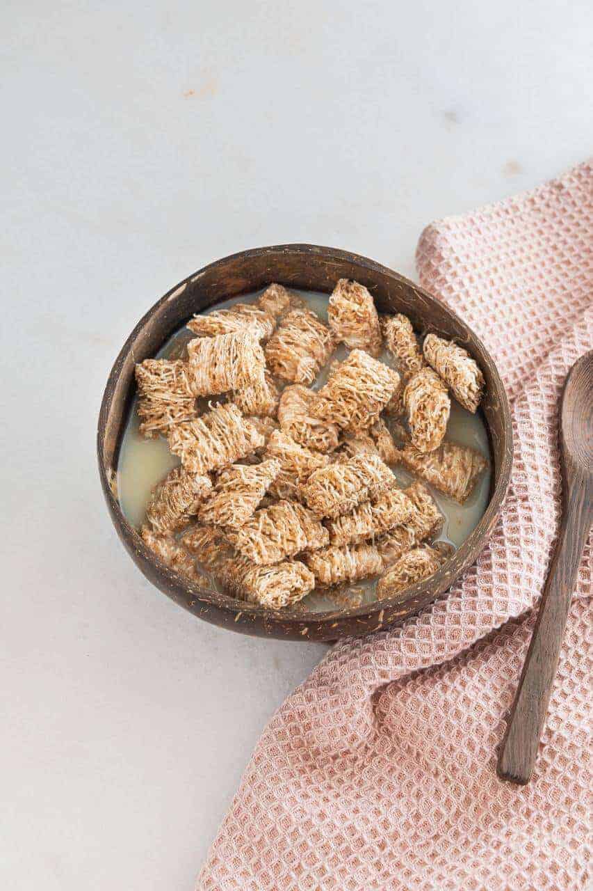 Bowl of shredded wheat cereal with milk.
