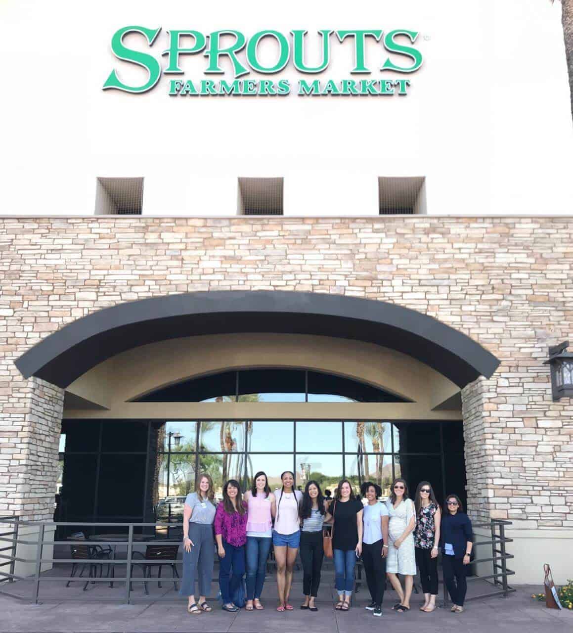 Group of women standing in front of a Sprouts grocery store.