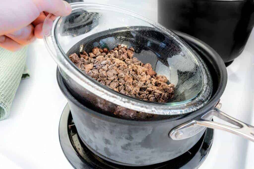 Saucepan with glass bowl and chocolate chips