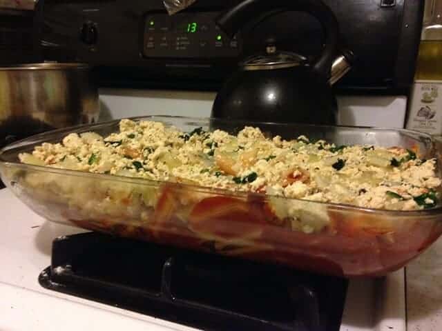 Baked tofu ricotta pasta in a rectangle dish on the stovetop.