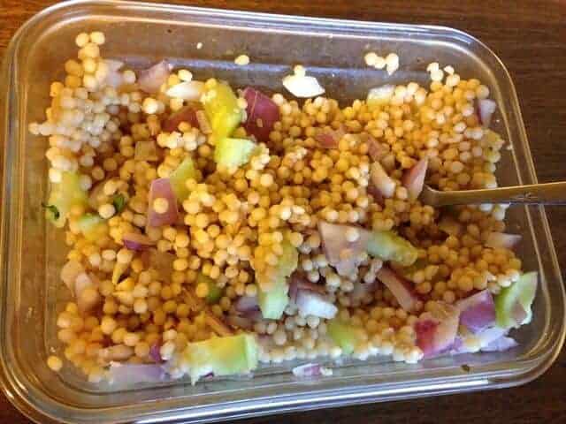 Glass container filled with Israeli couscous salad.