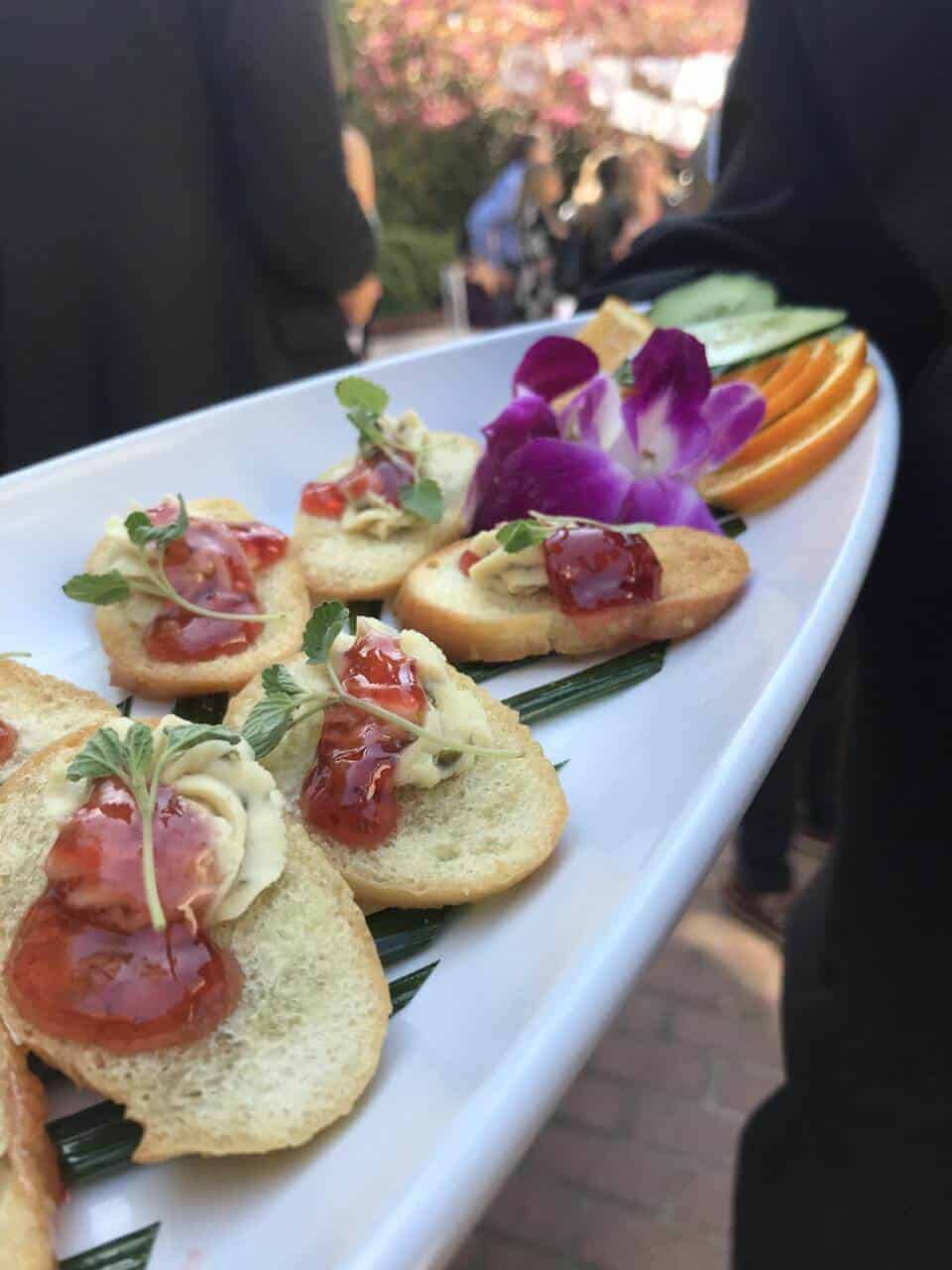 Close up of appetizer toasts on a long white platter.