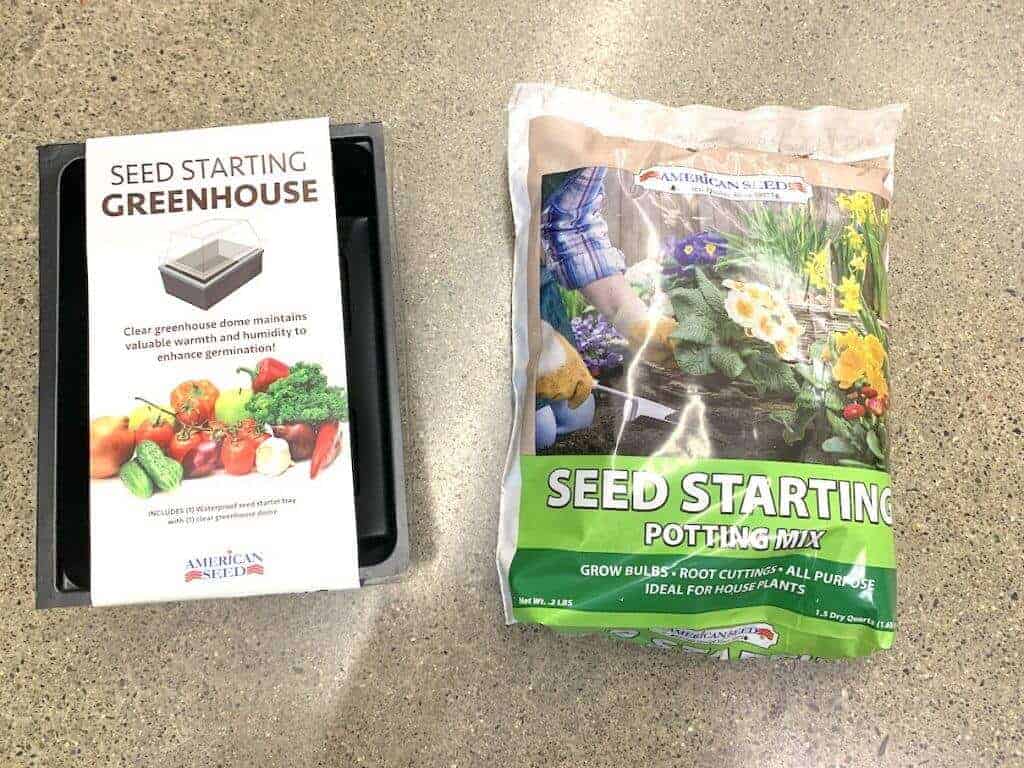 A bag of seed starting potting mix with a greenhouse seed starting kit.