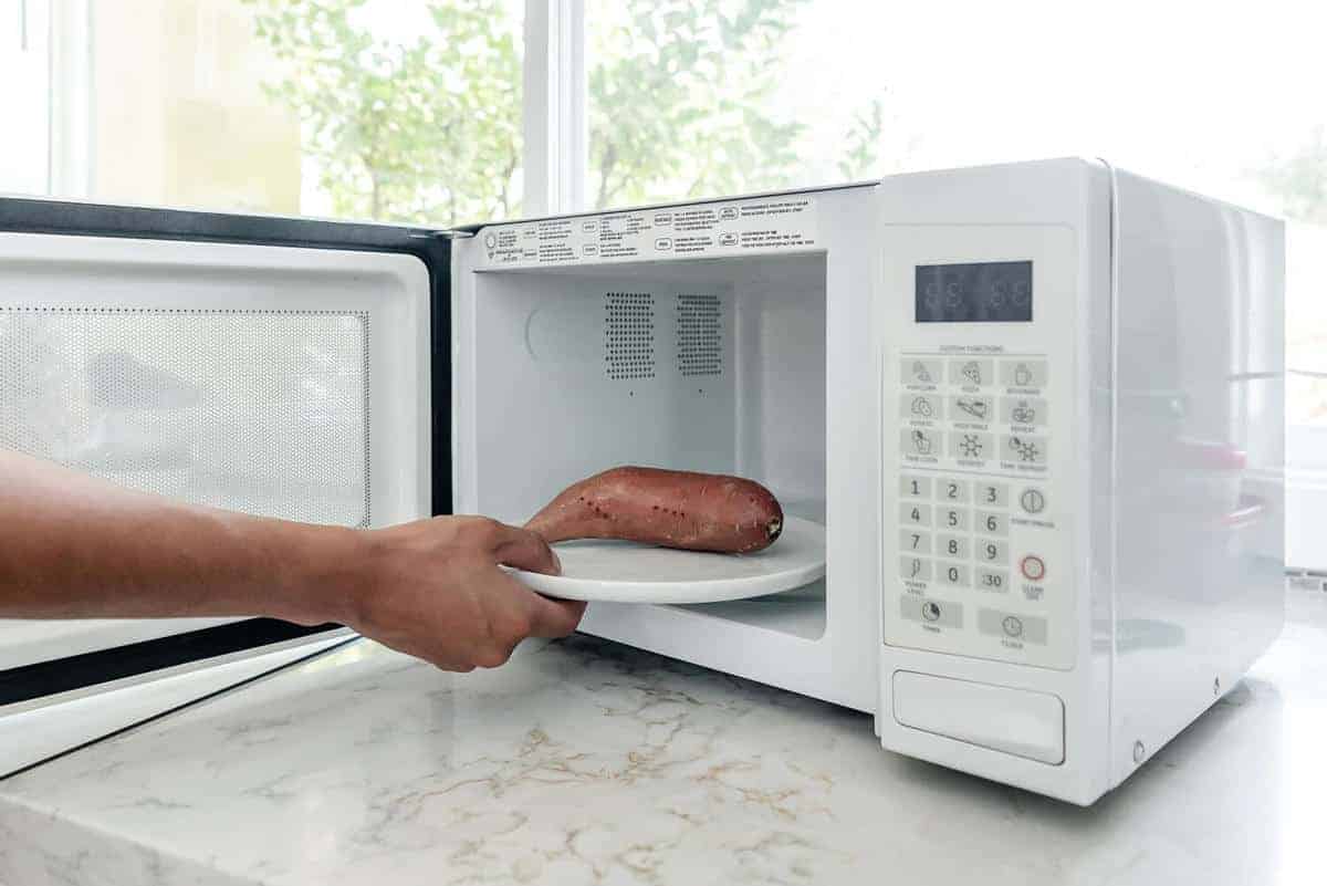 sweet potato being put in microwave