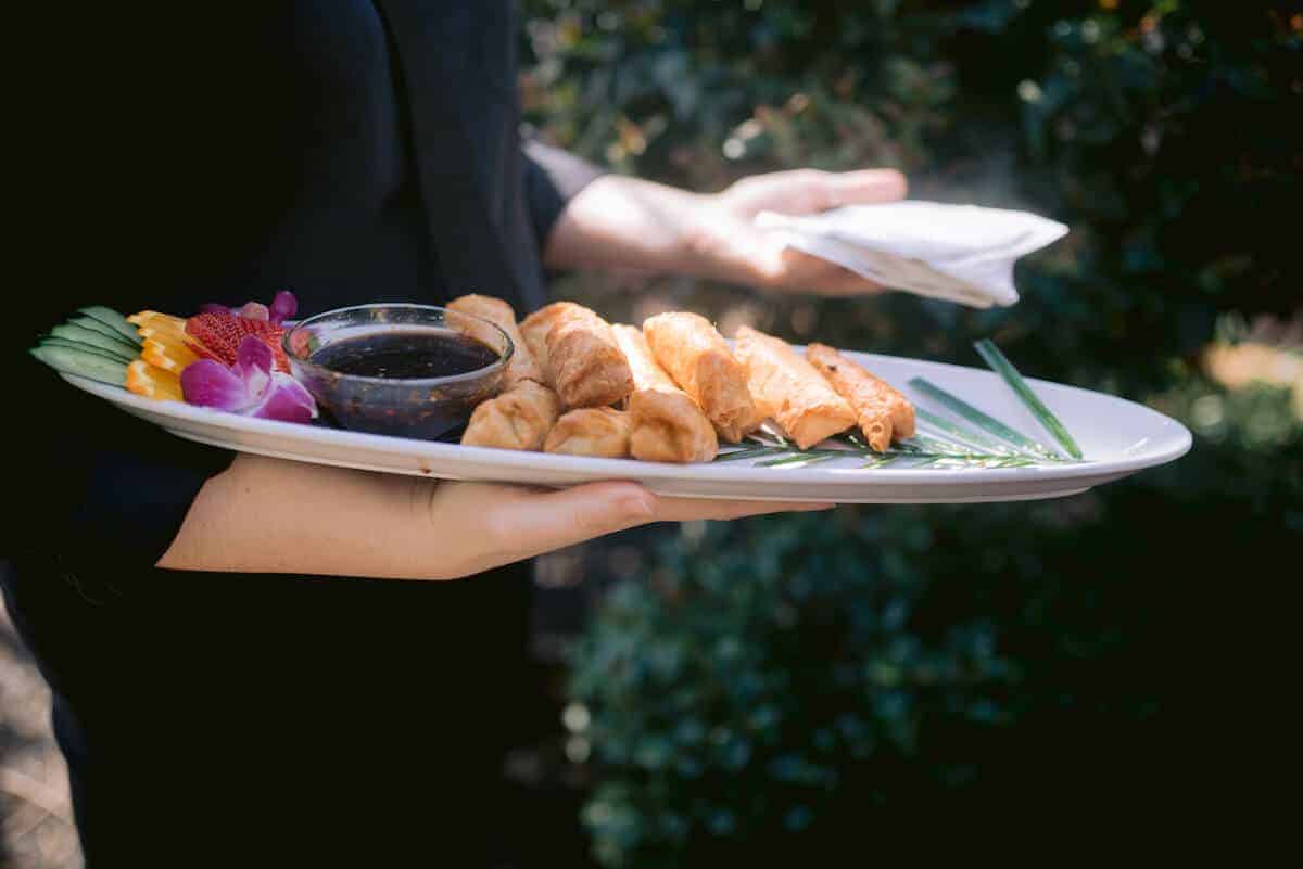 Waiter holding a passing appetizer tray plus napkins.
