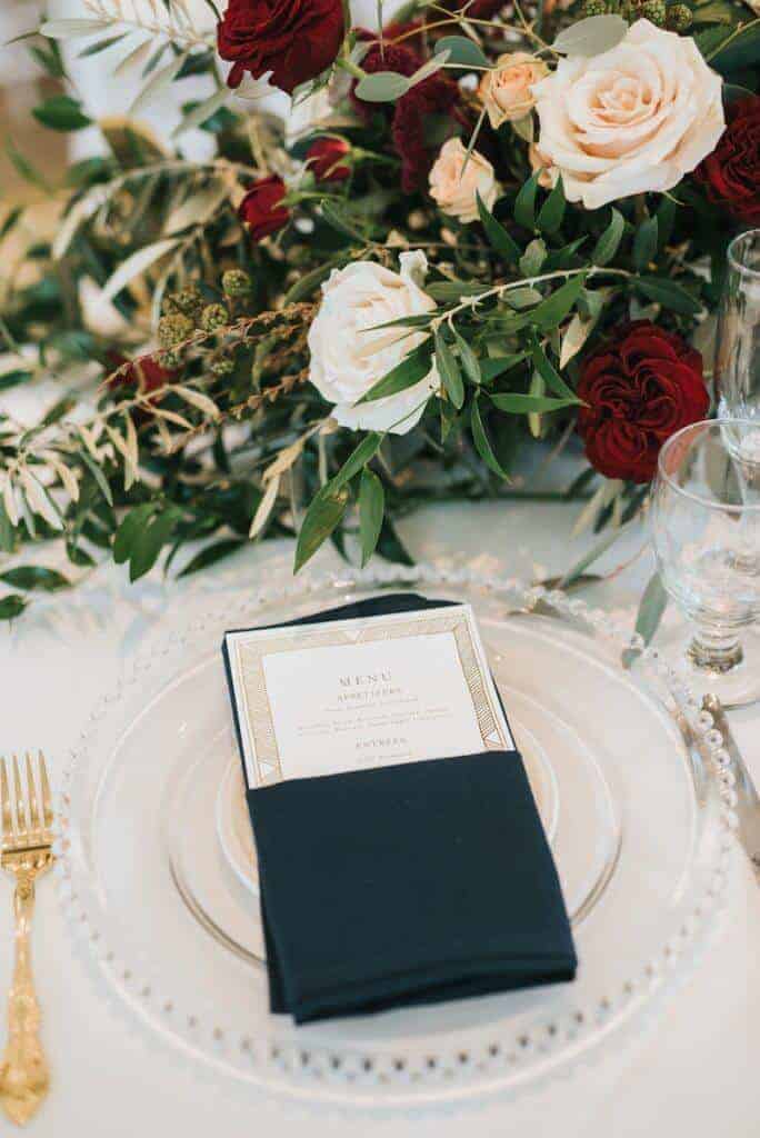 Wedding menu tucked in a napkin on a plate.