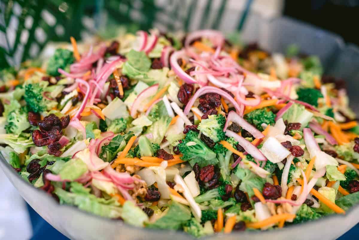 Closeup of a chopped broccoli salad in a large serving bowl.