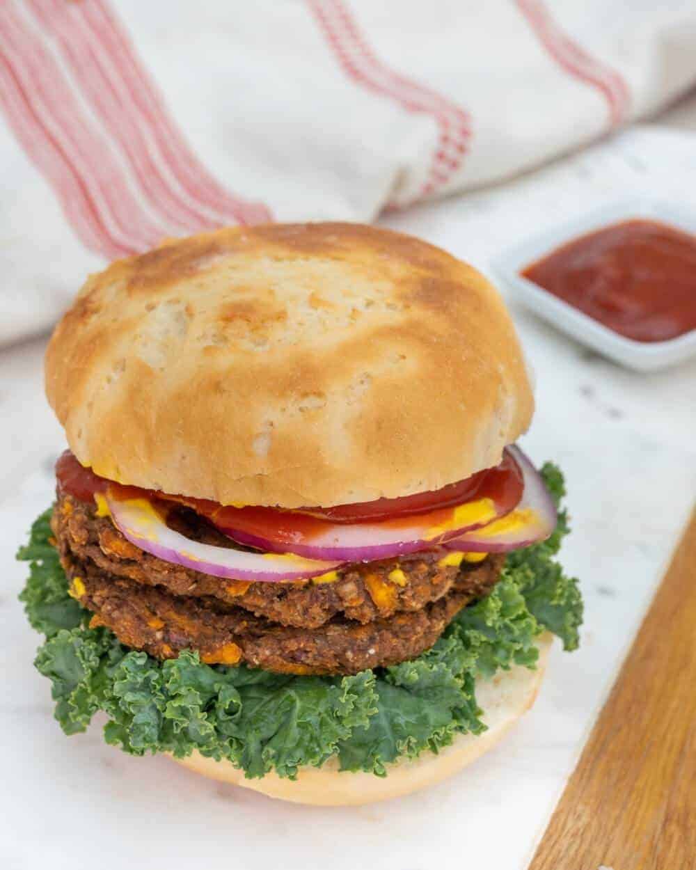 Sweet Potato & Jalapeño Burger on a white tray with a red and white towel and. sauce in a white background