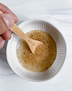 preparation of flax seed mixing into bowl of water against a white background