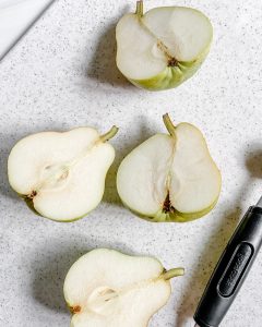 process - two pears cut in half against white background