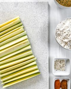 ingredients for Baked Zucchini Fries in a white background