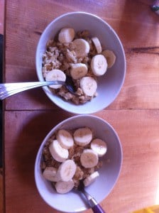 Two bowls of warm oatmeal topped with banana slices.