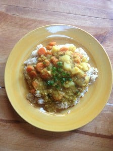 Dinner plate of brown rice topped with red lentil curry.